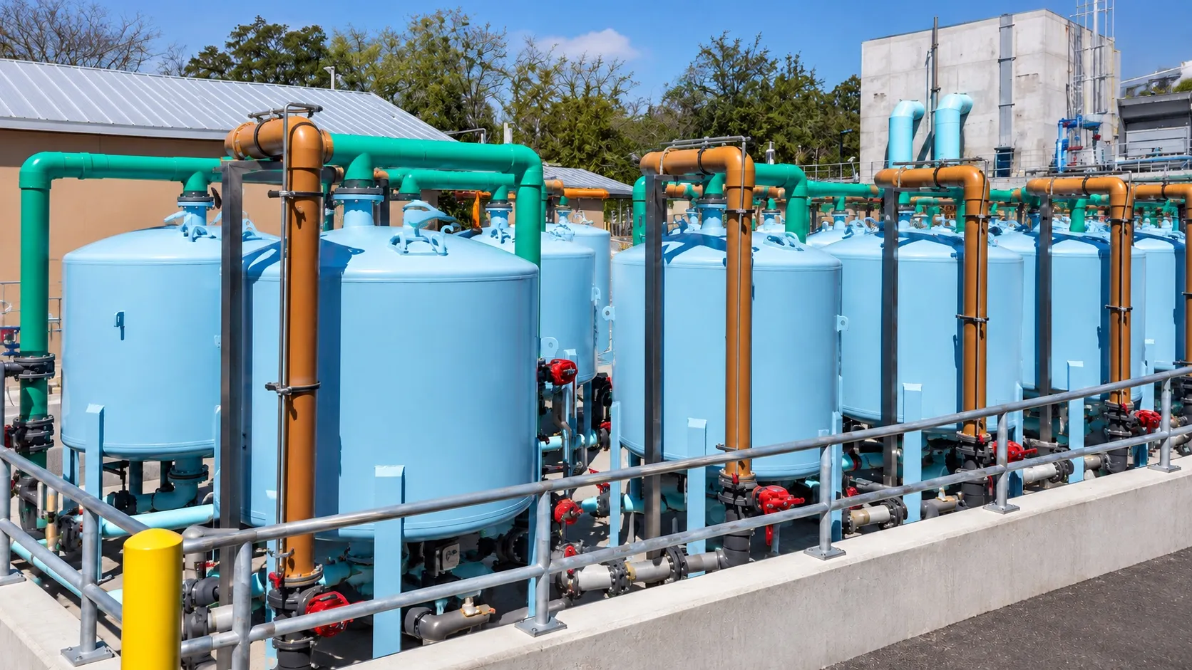 Bank of sand filter vessels with gauges and a valve header running the length of an equipment room